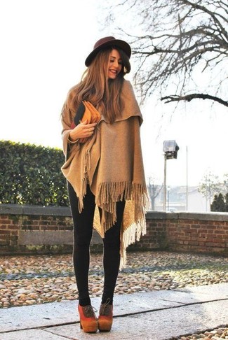 Super chic, this combination of a tan poncho and black leggings brings variety. Avoid looking too casual by rounding off with tan suede lace-up ankle boots.