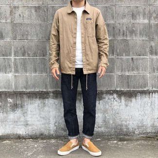 Slip-on Sneakers Outfits For Men: Pair a tan nylon shirt jacket with navy jeans for a casual and cool and trendy look. When in doubt as to the footwear, go with a pair of slip-on sneakers.