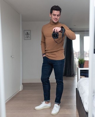 Tan Turtleneck Outfits For Men: A tan turtleneck and navy jeans are a combo that every fashion-forward man should have in his menswear arsenal. White canvas low top sneakers complement this look very nicely.