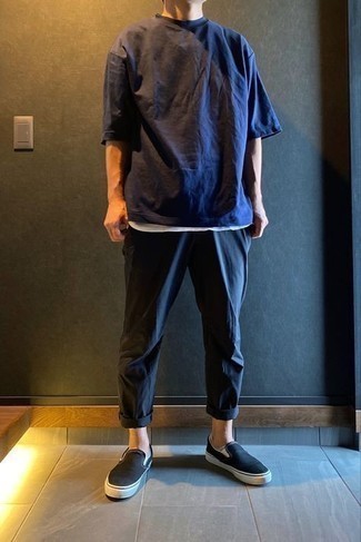 Black Canvas Slip-on Sneakers Outfits For Men: If you feel more confident wearing something comfortable, you'll like this on-trend combination of a navy crew-neck t-shirt and navy chinos. Let your styling skills really shine by finishing this outfit with black canvas slip-on sneakers.