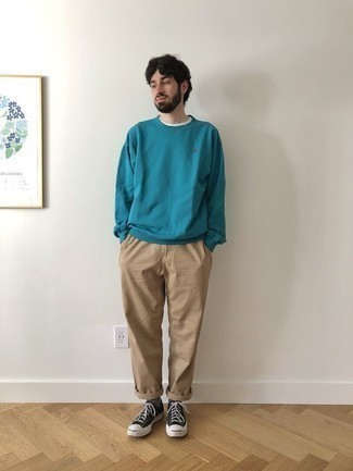 Men's Outfits 2022: This combination of a teal sweatshirt and khaki chinos brings comfort and practicality and helps keep it low-key yet trendy. Black and white canvas low top sneakers act as the glue that will pull your ensemble together.