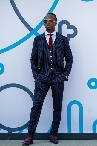 Burgundy Horizontal Striped Tie Outfits For Men: Opt for a navy vertical striped three piece suit and a burgundy horizontal striped tie for masculine elegance with a clear fashion twist. Infuse a more relaxed touch into this ensemble by sporting a pair of navy leather double monks.
