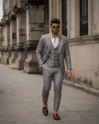Grey Three Piece Suit Outfits: Putting together a grey three piece suit and a white dress shirt is a guaranteed way to infuse your styling routine with some masculine sophistication. For a stylish hi-low mix, complete your ensemble with a pair of dark brown leather loafers.