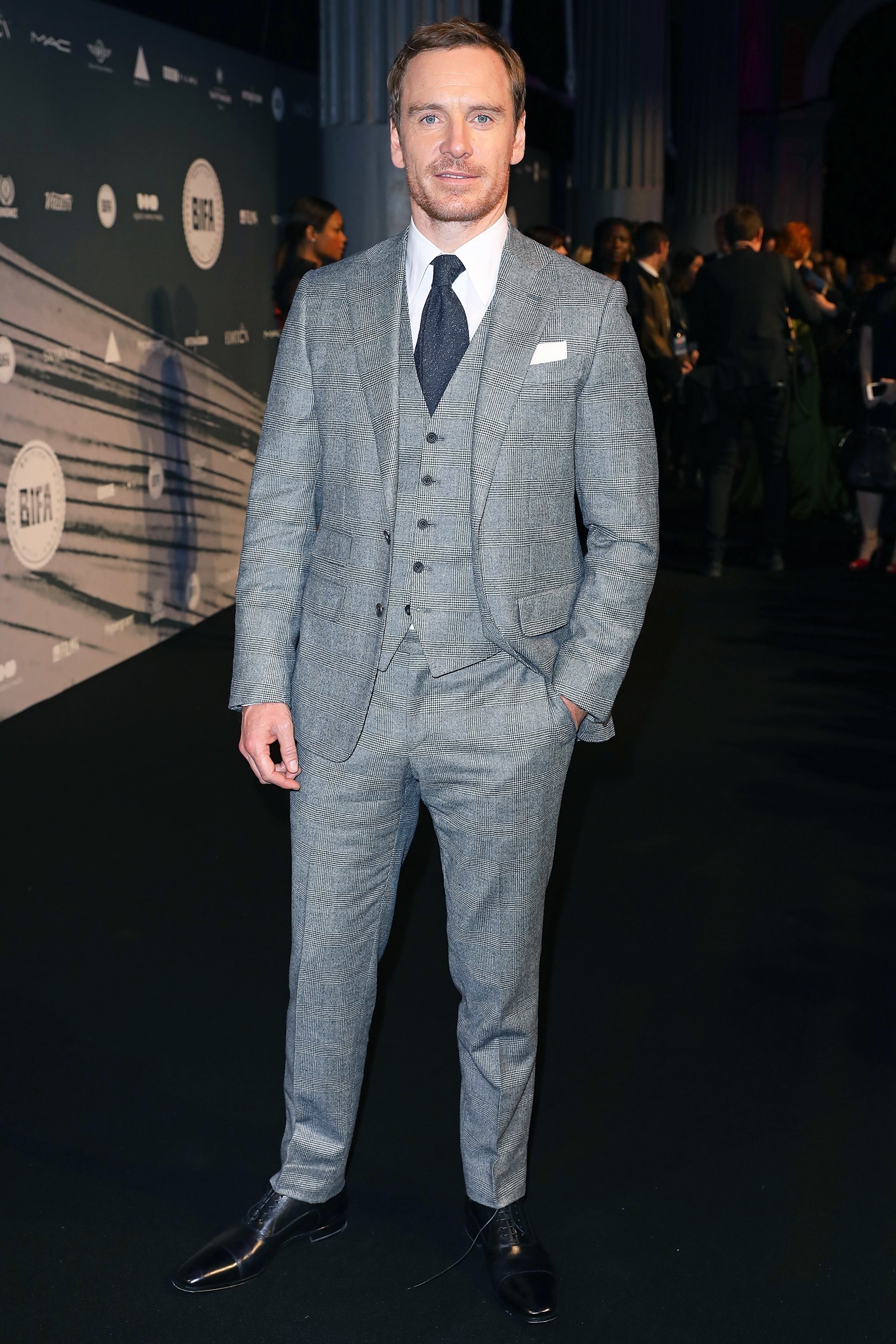 Michael Fassbender wearing Grey Plaid Three Piece Suit, White Dress Shirt,  Black Leather Oxford Shoes, Navy Wool Tie | Lookastic