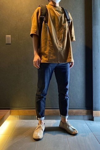 Brown Canvas Backpack Outfits For Men: If you gravitate towards contemporary looks, why not wear this pairing of a tobacco crew-neck t-shirt and a brown canvas backpack? For a modern hi-low mix, complete this outfit with a pair of beige suede desert boots.