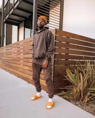 Tobacco Beanie Outfits For Men: This edgy combo of a dark brown track suit and a tobacco beanie is super easy to pull together in next to no time, helping you look seriously stylish and prepared for anything without spending too much time digging through your closet. Orange canvas sandals integrate really well within plenty of combos.