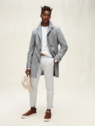 Trenchcoat Outfits For Men: Go for a pared down yet elegant choice by teaming a trenchcoat and grey chinos. Brown leather low top sneakers add a more dressed-down aesthetic to the getup.