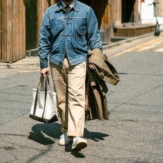 Tote Bag Outfits For Men: The go-to for a cool casual getup? A brown trenchcoat with a tote bag. Let your sartorial chops really shine by rounding off this outfit with a pair of white canvas low top sneakers.