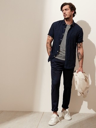 Navy Short Sleeve Shirt Outfits For Men: If you're a fan of relaxed casual combos, then you'll love this pairing of a navy short sleeve shirt and navy chinos. Complete your look with white canvas low top sneakers et voila, this look is complete.