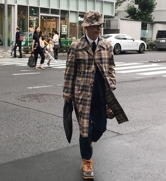 Tan Plaid Trenchcoat Outfits For Men: You'll be surprised at how extremely easy it is to throw together this elegant menswear style. Just a tan plaid trenchcoat teamed with a navy suit. And if you want to instantly dial down your ensemble with a pair of shoes, why not add tobacco leather snow boots to the mix?