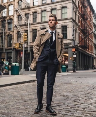 Navy Suit Outfits: Combining a navy suit and a tan trenchcoat is a fail-safe way to breathe masculine refinement into your wardrobe. Give an easy-going touch to your look by finishing off with black leather derby shoes.