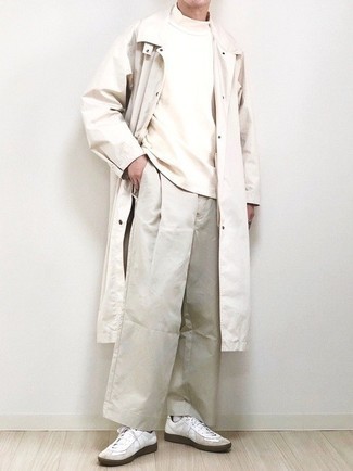 White Trenchcoat Outfits For Men: This ensemble clearly illustrates that it is totally worth investing in such menswear must-haves as a white trenchcoat and beige chinos. Finishing with a pair of white leather low top sneakers is a guaranteed way to introduce a more casual finish to your look.