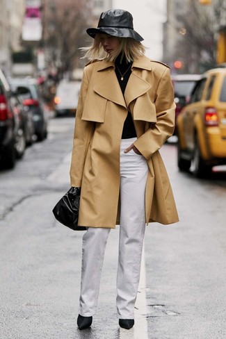 Bucket Hat Outfits For Women: This relaxed casual pairing of a tan trenchcoat and a bucket hat is very easy to pull together without a second thought, helping you look amazing and prepared for anything without spending too much time going through your wardrobe. You can get a little creative in the shoe department and introduce black satin ankle boots to the equation.