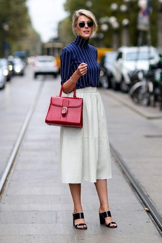 White and Black Skirt Outfits: Irrefutable proof that a navy vertical striped turtleneck and a white and black skirt look amazing paired together in an off-duty ensemble. Bring a sultry vibe to this getup by slipping into a pair of black leather heeled sandals.
