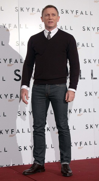 Daniel Craig wearing Black V-neck Sweater, White Dress Shirt, Charcoal Jeans, Burgundy Leather Brogue Boots