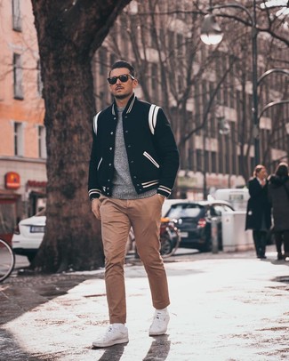Black and White Varsity Jacket Outfits For Men: For a casual look, wear a black and white varsity jacket and khaki chinos — these pieces go perfectly together. Complete this getup with a pair of white low top sneakers and you're all set looking smashing.