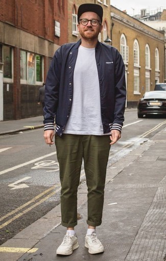 Navy Varsity Jacket Outfits For Men: Marry a navy varsity jacket with olive chinos to achieve an everyday look that's full of style and personality. Add white athletic shoes to easily ramp up the street cred of this getup.