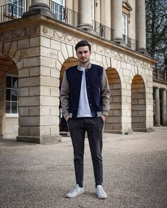 Blue Varsity Jacket Outfits For Men: A blue varsity jacket and charcoal chinos will infuse your daily repertoire this casually cool vibe. White canvas low top sneakers are the glue that ties your ensemble together.
