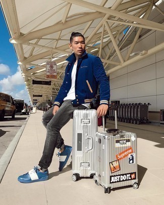 Grey Suitcase Outfits For Men: This casual pairing of a navy varsity jacket and a grey suitcase is perfect when you need to look dapper in a flash. Blue leather low top sneakers are an effortless way to add a little kick to the look.