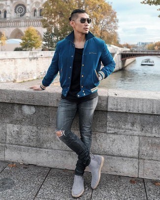 Navy Varsity Jacket Outfits For Men: A navy varsity jacket and charcoal ripped jeans are a cool combo worth incorporating into your casual fashion mix. For a modern mix, add a pair of grey suede chelsea boots to the equation.