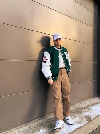 White Leather Low Top Sneakers Warm Weather Outfits For Men: The versatility of a dark green varsity jacket and khaki jeans means they will be on high rotation. All you need now is a nice pair of white leather low top sneakers to finish your ensemble.