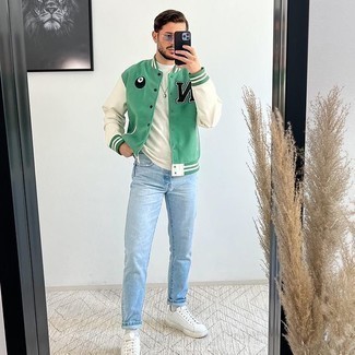 Varsity Jacket Casual Outfits For Men: One of the most popular ways for a man to style out a varsity jacket is to combine it with light blue jeans for a casual combo. White leather low top sneakers are the ideal complement for this outfit.