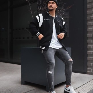 Black and White Varsity Jacket Outfits For Men: Wear a black and white varsity jacket and grey ripped skinny jeans to get an edgy and practical outfit. Complement your ensemble with a pair of white and black canvas low top sneakers to avoid looking too casual.