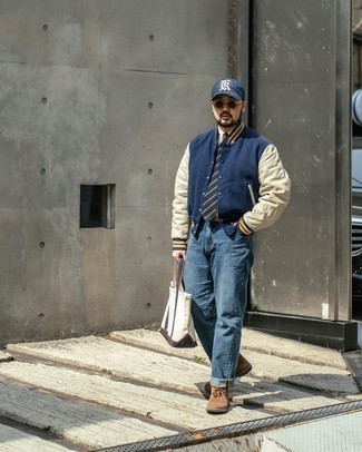 Tote Bag Outfits For Men: This combination of a navy varsity jacket and a tote bag is ridiculously dapper and yet it's easy enough and ready for anything. A good pair of brown suede desert boots is an easy way to power up your getup.