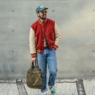 Varsity Jacket Outfits For Men: This is hard proof that a varsity jacket and light blue jeans look amazing together in a laid-back outfit. Let your sartorial chops truly shine by finishing with a pair of green canvas low top sneakers.