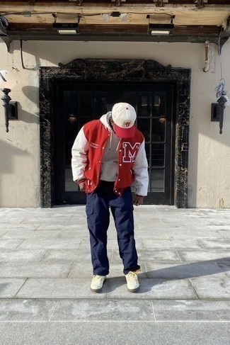 Red and White Varsity Jacket Outfits For Men: This pairing of a red and white varsity jacket and navy cargo pants is undeniable proof that a simple casual outfit can still look seriously dapper. Our favorite of a multitude of ways to complement this look is white canvas low top sneakers.