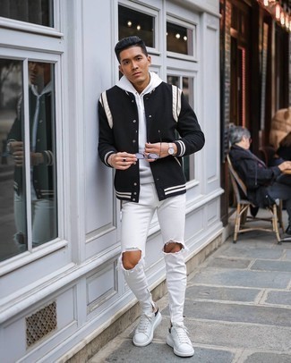 Black and White Varsity Jacket Outfits For Men: Go for a simple but casually stylish option pairing a black and white varsity jacket and white ripped skinny jeans. Introduce white and black leather low top sneakers to the mix for an air of refinement.