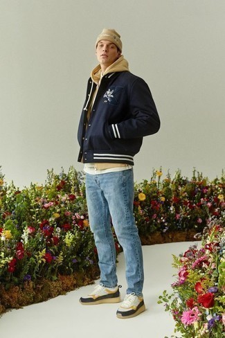 500+ Fall Outfits For Men: A navy print varsity jacket and light blue jeans are absolute menswear staples that will integrate nicely within your daily outfit choices. A pair of white leather low top sneakers looks perfect finishing off this outfit. It's a viable choice if you're putting together a killer look for in-between weather.