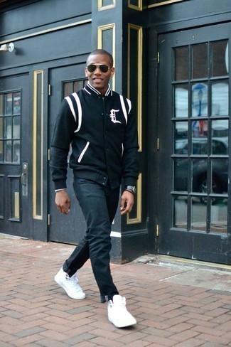 Black and White Varsity Jacket Outfits For Men: Opt for a black and white varsity jacket and navy jeans for a kick-ass ensemble. Complement this outfit with white canvas high top sneakers to have some fun with things.