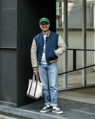 White Canvas Tote Bag Outfits For Men: This is irrefutable proof that a navy varsity jacket and a white canvas tote bag are awesome when worn together in a bold casual outfit. Tap into some Idris Elba stylishness and smarten up your ensemble with navy and white canvas low top sneakers.