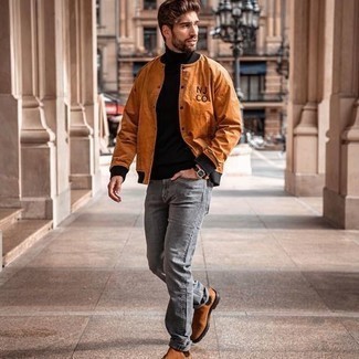 Tobacco Varsity Jacket Outfits For Men: Look stylish yet relaxed casual by opting for a tobacco varsity jacket and grey jeans. Finishing with tobacco suede chelsea boots is a guaranteed way to introduce some extra zing to your look.