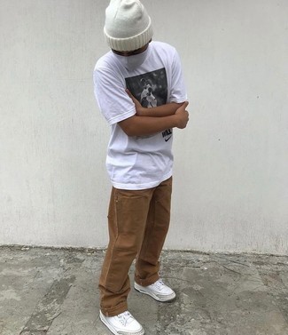 White Beanie Outfits For Men: A white and black print crew-neck t-shirt and a white beanie are an edgy pairing that every stylish gent should have in his wardrobe. Complement this ensemble with white leather low top sneakers to effortlessly dial up the fashion factor of this outfit.