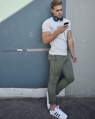 White Leather Low Top Sneakers Hot Weather Outfits For Men: Consider wearing a white and black print crew-neck t-shirt and olive chinos to achieve new levels in your personal style. If you're hesitant about how to finish, a pair of white leather low top sneakers is a good choice.
