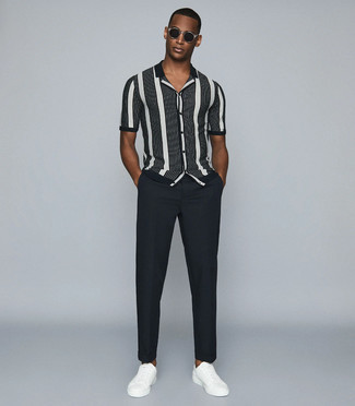 White and Black Vertical Striped Short Sleeve Shirt Outfits For Men: Stylish yet practical, this getup is comprised of a white and black vertical striped short sleeve shirt and charcoal chinos. The whole look comes together quite nicely when you introduce white leather low top sneakers to your getup.