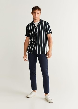 White and Black Vertical Striped Short Sleeve Shirt Outfits For Men: For an outfit that's pared-down but can be flaunted in a multitude of different ways, consider teaming a white and black vertical striped short sleeve shirt with navy chinos. White canvas low top sneakers act as the glue that ties this getup together.