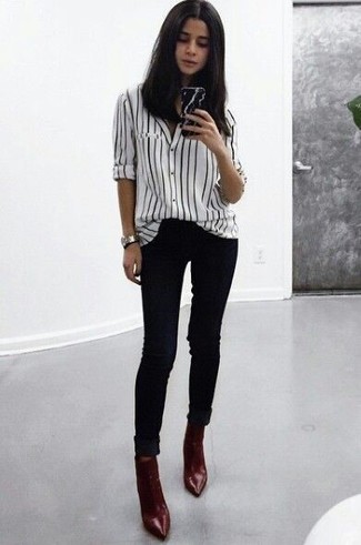 White and Black Vertical Striped Dress Shirt Outfits For Women: This relaxed casual combination of a white and black vertical striped dress shirt and black skinny jeans is extremely easy to throw together in no time, helping you look cute and prepared for anything without spending too much time rummaging through your closet. A pair of burgundy leather ankle boots finishes this outfit quite well.