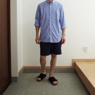 121 Relaxed Outfits For Men: A white and blue vertical striped long sleeve shirt and navy check shorts are the kind of a winning casual getup that you need when you have no time. If you wish to easily dial down your look with footwear, why not introduce a pair of black suede sandals to the mix?