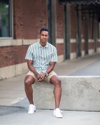 Beige Shorts Outfits For Men: Extremely stylish and comfortable, this casual pairing of a white and green vertical striped short sleeve shirt and beige shorts delivers variety. White canvas low top sneakers are sure to leave the kind of impression you want to give.