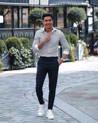 Navy Plaid Chinos Outfits: Pair a white and navy vertical striped long sleeve shirt with navy plaid chinos to pull together an interesting and current casual ensemble. A pair of white leather low top sneakers looks perfect here.