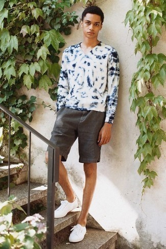 Men's Outfits 2022: A white and navy tie-dye v-neck sweater and charcoal shorts have become an essential combination for many stylish men. Complete your ensemble with a pair of white canvas low top sneakers and you're all set looking smashing.