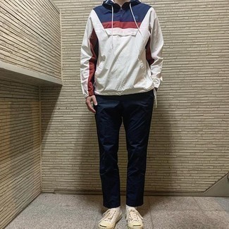Multi colored Windbreaker Outfits For Men: Sharp yet practical, this getup features a multi colored windbreaker and navy chinos. When not sure about the footwear, stick to beige canvas low top sneakers.