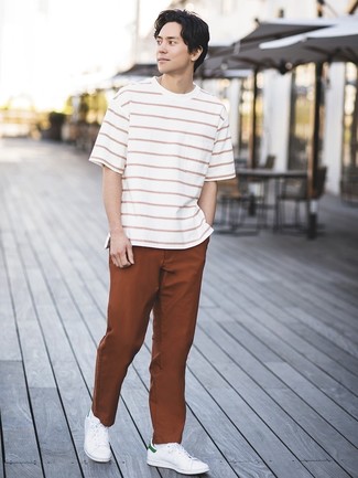 Brown Chinos Hot Weather Outfits: A white and red horizontal striped crew-neck t-shirt looks so good when matched with brown chinos in a laid-back look. A pair of white leather low top sneakers will tie your whole look together.