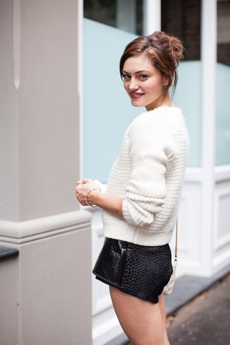 This combination of a white cable sweater and black leather shorts is an obvious choice for off duty.