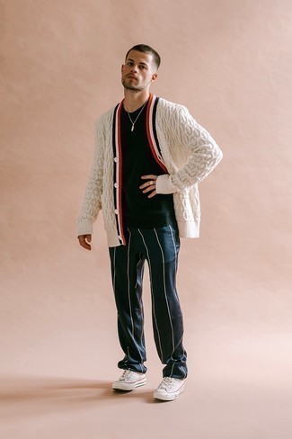 Knit Cardigan Outfits For Men: A knit cardigan and navy vertical striped chinos are the kind of a foolproof casual combo that you so awfully need when you have zero time. White canvas low top sneakers are a great option to finish this ensemble.