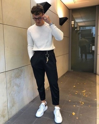 White and Black Leather Low Top Sneakers Outfits For Men: This off-duty combo of a white crew-neck sweater and black sweatpants is a goofproof option when you need to look casual and cool but have no extra time. Complement this ensemble with white and black leather low top sneakers and off you go looking killer.