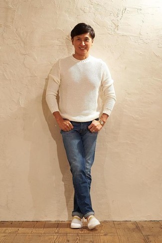 White Canvas Slip-on Sneakers Outfits For Men: Dress in a white crew-neck sweater and blue jeans for a casual and stylish look. White canvas slip-on sneakers make your look complete.